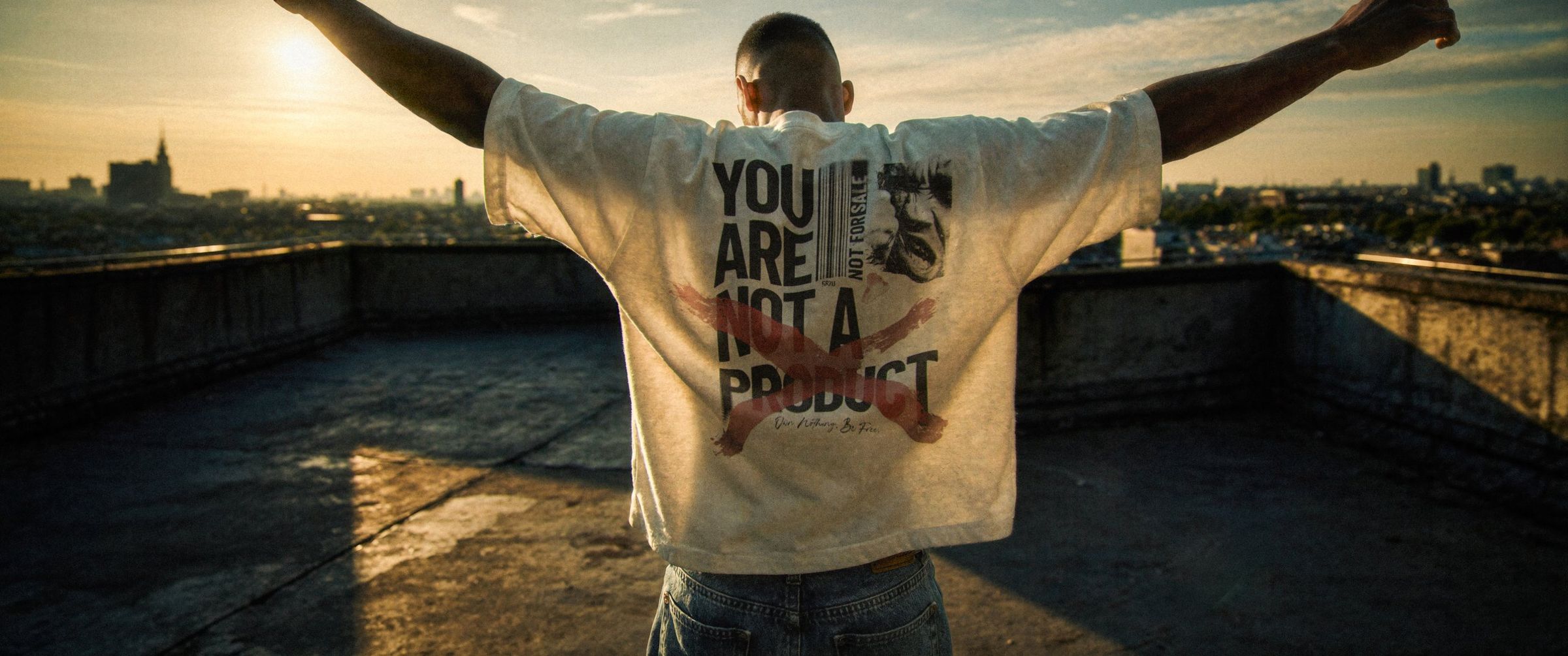Film Art Wear — Rückenprint „You are not a product“ im Gegenlicht über der Stadt