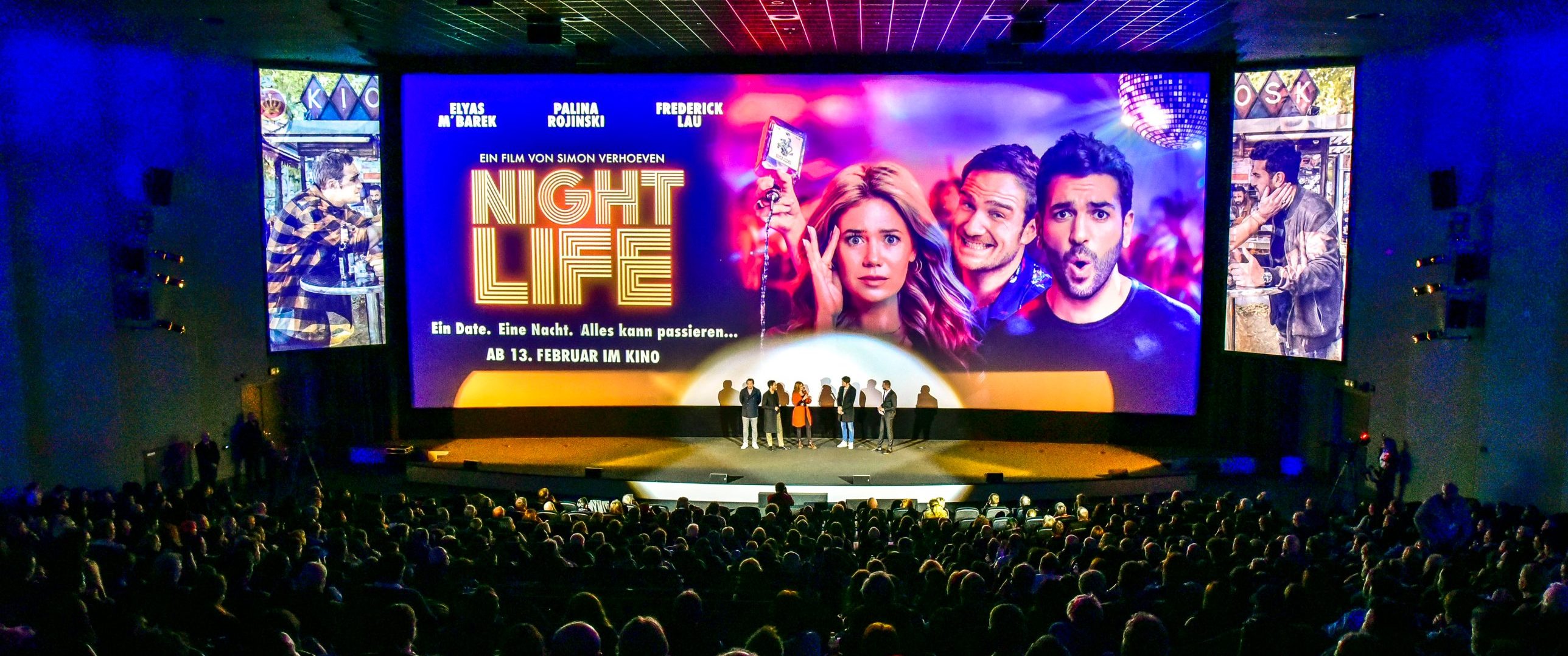 Voller Kinosaal bei einer Premiere, Publikum vor der Leinwand